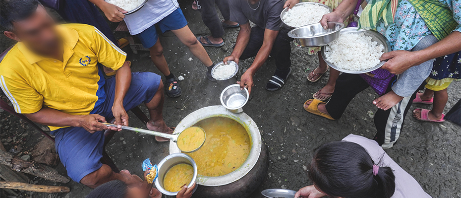 Refugees from Manipur eat food together