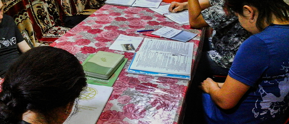 Women in South East Asia are gathered round a table for Bible study
