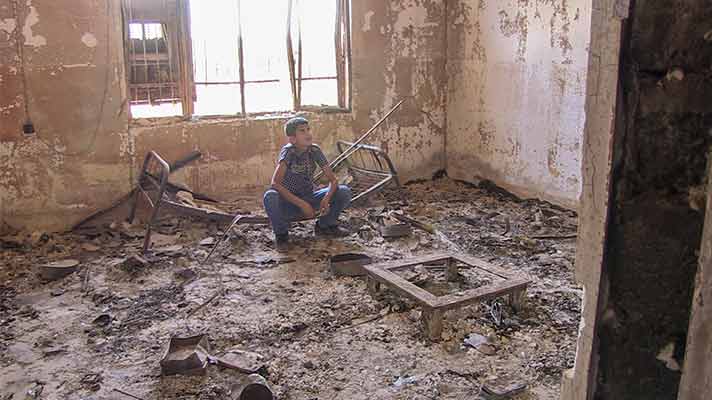 Noeh in his burned out room, destroyed by the self-proclaimed Islamic State.