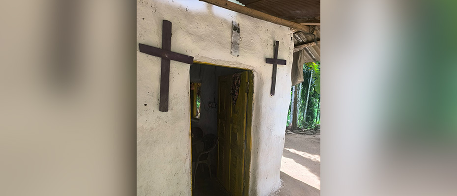 A house in a Sri Lankan village with two crosses on the door posts.
