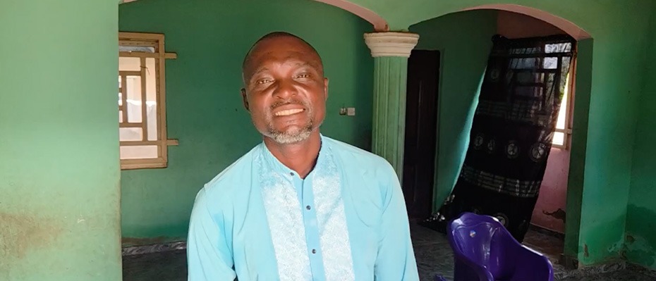Man smiles wearing a blue top