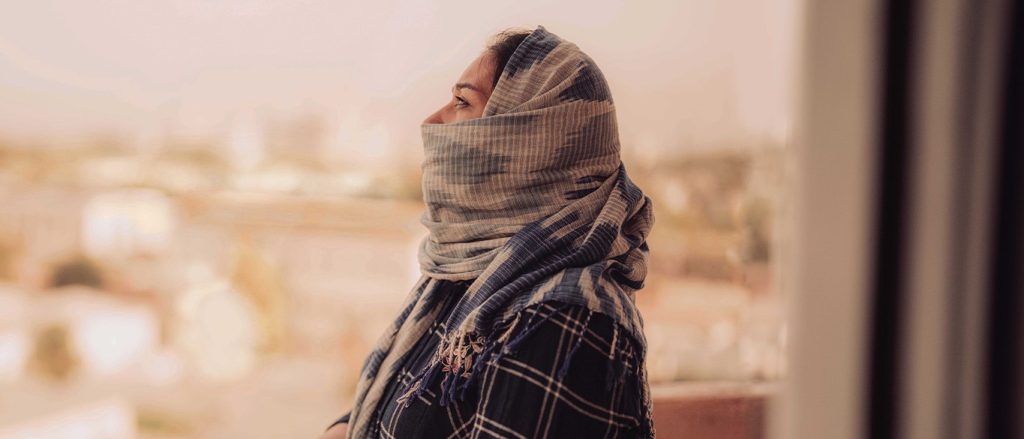 Woman wearing a headscarf and looking at the sky