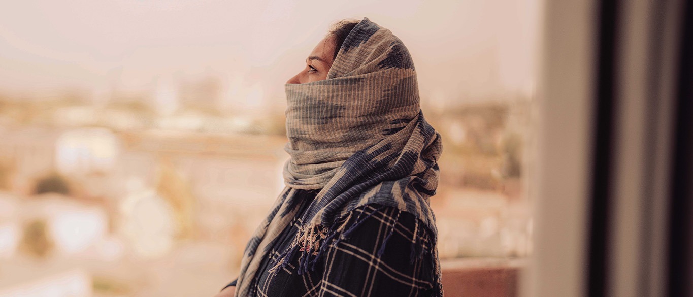 Woman wearing a headscarf and looking at the sky