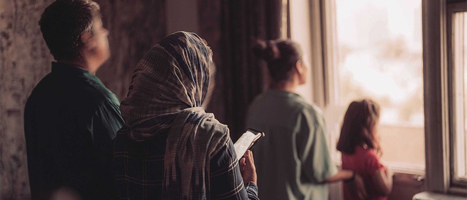A woman and her family look out of a window