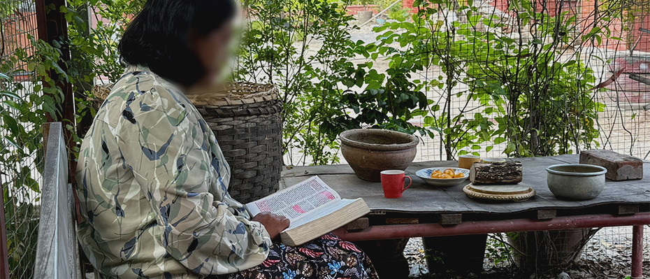 A woman reads a book at a table