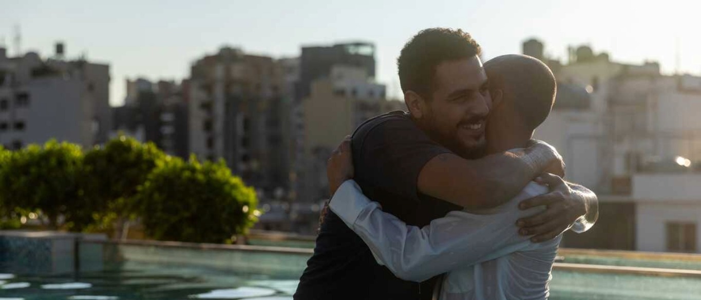 Two men hugging each other in a pool