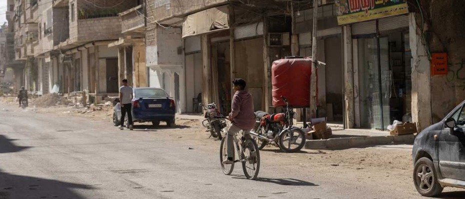 A boy cycling down a street in Syria