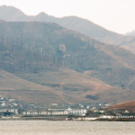 A view of mountains and a village by a lake