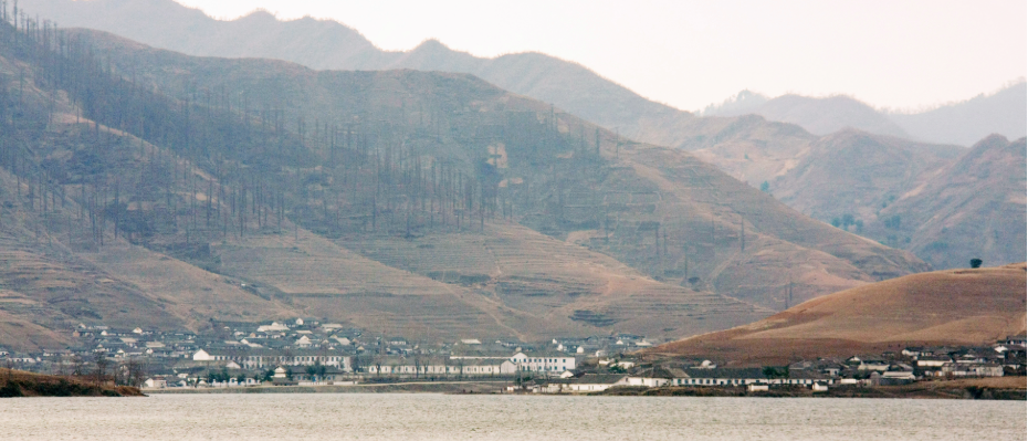 A view of mountains and a village by a lake