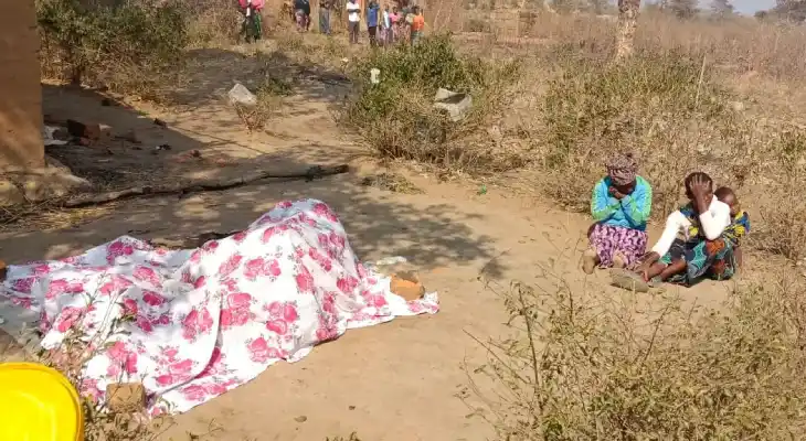 Two women next to a covered body in the DRC