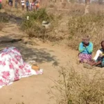 Two women next to a covered body in the DRC