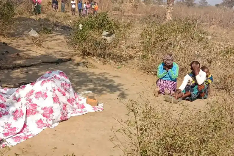 Two women next to a covered body in the DRC