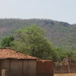 A village with mountains in the background in Chhattisgarh, India.