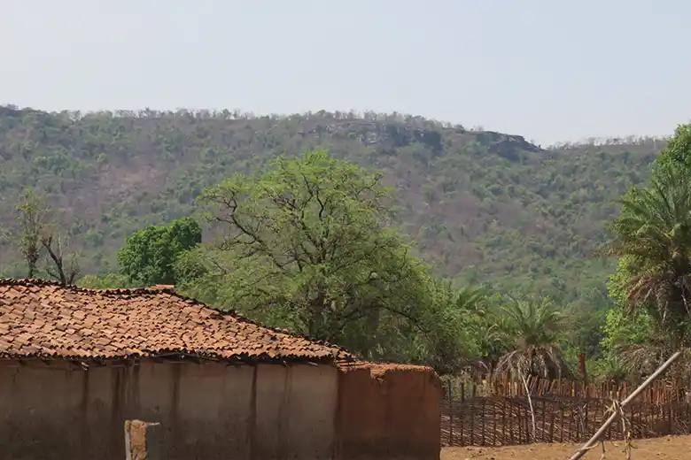 A village with mountains in the background in Chhattisgarh, India.